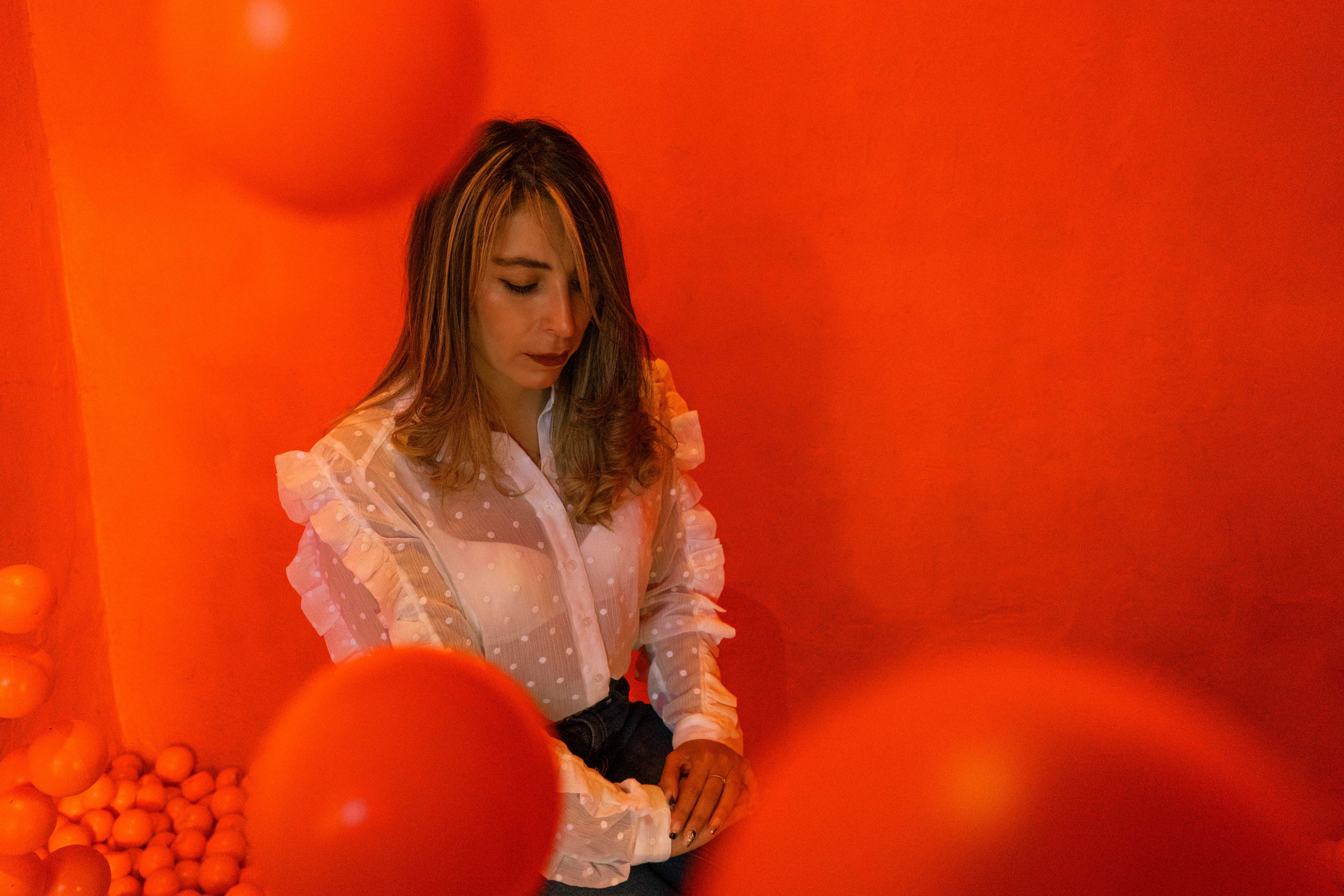 woman in white long sleeve shirt holding orange balloons